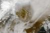On 21 May 2011, Grimsvoetn volcano rumbled to life and sent off a plume of ash and steam about 20 km (12 mi) into the atmosphere. Above Grimsvoetn's summit, volcanic ash formed a circular brown plume that towered above the surrounding clouds. In the southeast, ash colored the snow surface dark brown. Ash from the volcano also reduced visibility to about 50 m (160 ft) in some areas, causing night-like darkness in the middle of the day. Image courtesy of NASA.