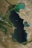 Measured by surface area, the Caspian Sea is the world's largest inland water body. It covers roughly 371,000 sq km (143,200 sq mi) and borders five countries. To the ancient Greeks and Persians, the lake's immense size suggested it was an ocean, hence its name. A large expanse of clear sky permitted this natural-color satellite image of the entire water body. The color of the Caspian Sea darkens from north to south, thanks to changes in depth and perhaps sediment and other runoff. The northern part of the lake is just 5 to 6 m (16 to 20 ft) deep. The southern end, however, plunges more than 1,000 m (3,300 ft). Just as the lake reaches a greater depth in the south, the nearby land reaches a greater height. The mountains of northern Iran line the southern end of the giant lake, and emerald green vegetation clings to those mountain slopes. In marked contrast to the mountains, sand seas line the southeastern and northern perimeters of the lake, and marshes occur along the lake shores in Azerbaijan to the west. Multiple rivers empty into the Caspian Sea, the Volga being the largest. Lacking an outlet, the Caspian Sea loses water only by evaporation, leading to the accumulation of salt. Although a lake, the Caspian is not a freshwater lake; the water delivered by the Volga River minimizes the lake's salt content at the northern end, but the Caspian grows more saline to the south. Kara-Bogaz-Gol is a saline inlet along the lake's eastern perimeter. Image courtesy of NASA. 