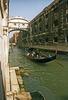 Gondola on a Venetian canal approaching the Bridge of Sighs. 