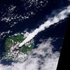 The thick, steam-rich plume from Guau Volcano blows directly northeast in this natural-color satellite image acquired on 24 April 2010. The thick steam is brighter white than the surrounding lower-altitude clouds. Vegetation is green, as is Lake Letas. Vegetation to the south and west of the volcano, damaged by ash and acidic volcanic gases, is dark gray-brown. Photo courtesy of NASA. 