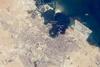 The old and new zones of Doha, the capital city of Qatar, are clearly visible from the International Space Station. The old city comprises the ancient bazaar, or Souq, near the dhow harbor, which is still used today for traditional Arab sailing vessels. Modern port facilities have sprung up to the east of the Souq.

Subsequent developments have sprouted progressively further from the ancient center, with ring roads concentrically arranged around it. The diplomatic quarter is reached via the waterfront Corniche promenade, north of the old city. Further away, an extensive marina known as West Bay Lagoon, with boating access to the Persian Gulf, stands out (image top).

Qatar's new artificial island, known as the Pearl-Qatar, is under construction with 32 km of new coastline just offshore of West Bay Lagoon. This development is intended mainly as a residential zone, with themes based on Arabic, Mediterranean, and European cultures. The Pearl-Qatar is so named because it is being built on one of Qatar's historical pearl diving sites. A string of small islands built along the outer margin is intended to recall the pearl-diving culture of the nation's past. Image courtesy of NASA.