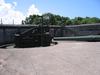 A 10-inch coast artillery gun and a "disappearing" mount emplaced in Battery Grubbs on Fort Mills (Corregidor). This type of mount is designed to employ a hinged counterweight to raise the gun for firing above the parapet of the gun emplacement and then to recoil back and down under cover for reloading. Fort Mills had 23 batteries with 56 coast artillery guns and mortars, of which six batteries were equipped with disappearing mounts. In addition, there were 13 anti-aircraft batteries with 76 guns.