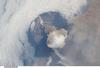 A fortuitous orbit of the International Space Station allowed the astronauts to take this striking view of Sarychev Peak volcano (Russia's Kuril Islands, northeast of Japan) in an early stage of eruption on 12 June 2009. Sarychev Peak is one of the most active volcanoes in the Kuril Island chain and is located on the northwestern end of Matua Island. Prior to 12 June, the last explosive eruption had occurred in 1989 with eruptions in 1986, 1976, 1954, and 1946 also producing lava flows. 

This detailed photograph is exciting to volcanologists because it captures several phenomena that occur during the earliest stages of an explosive volcanic eruption. The main column is one of a series of plumes that rose above Matua Island on June 12. The plume appears to be a combination of brown ash and white steam. The vigorously rising plume gives the steam a bubble-like appearance; the surrounding atmosphere has been shoved up by the shock wave of the eruption. The smooth white cloud on top may be water condensation that resulted from rapid rising and cooling of the air mass above the ash column, and is probably a transient feature (the eruption plume is starting to punch through). 

The structure also indicates that little or no shearing winds were present at the time to disrupt the plume. By contrast, a cloud of denser, gray ash - most probably a pyroclastic flow - appears to be hugging the ground, descending from the volcano summit. The rising eruption plume casts a shadow to the northwest of the island (bottom center).

Brown ash at a lower altitude of the atmosphere spreads out above the ground at upper right. Low-level stratus clouds approach Matua Island from the east, wrapping around the lower slopes of the volcano. Only about 1.5 km (1 mi) of the coastline of Matua Island (upper center) can be seen beneath the clouds and ash. Image courtesy of NASA.

