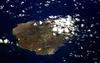 An oblique view of rugged Ascension Island, which is is barren in many places and has no indigenous human population. Instead the residents of the island are there because of Ascension's main industry: communications. The island has a long history as a communications hub for telephone and radio communications and as a base for satellite tracking stations, including a NASA station built in the 1960s that no longer operates. The European Space Agency operates a tracking station for its Ariane spacecraft on the eastern side of the island. 

Ascension Island is one of the most important breeding grounds for seabirds in the tropical Atlantic Ocean. The population of seabirds has been under threat since the first humans sailed up to the island in the 1500s. The ships accidentally introduced black rats, which overran the island, until cats were introduced to curb the rat population. The feral cats have decimated the bird populations, and in fact, are probably responsible for the extinction of two of the islands native land birds. A restoration project is underway to control the cat population and revive the seabirds. Image courtesy of NASA.