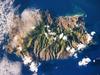 Saint Helena's rugged topography of sharp peaks and deep ravines - evident in this photograph from the International Space Station - is the result of erosion of the volcanic rocks that make up the island. A climatic gradient related to elevation is also evident - the higher, wetter central portion of the island is covered with green vegetation, whereas the lower coastal areas are drier and hotter with little vegetation cover. Image courtesy of NASA.  