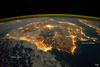 The city lights of Spain and Portugal define the Iberian Peninsula in this photograph taken from the International Space Station (ISS) on 4 December 2011. Several large metropolitan areas are visible, marked by their relatively large and brightly lit areas, such as the capital cities of Madrid, Spain - located near the center of the peninsula's interior - and Lisbon, Portugal - located along the southwestern coastline. The ancient city of Seville, visible at image right to the north of the approximately 14 km (9 mi)-wide Strait of Gibraltar, is one of the largest cities in Spain. The view is looking outwards from the ISS towards the east.

The network of smaller cities and towns in the interior and along the coastline attest to the areal extent of human presence on the Iberian landscape. Blurring of the city lights is caused by thin cloud cover (image left and center), while the cloud tops are dimly illuminated by moonlight. Though obscured, the lights of France are visible near the horizon line at image upper left, while the lights of northern Africa are more clearly discernable at image right. The gold to green line of airglow, caused by excitation of upper atmosphere gas molecules by ultraviolet radiation, parallels the horizon line (or Earth limb). Image courtesy of NASA.