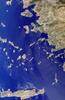 This image includes many of the islands of the East Aegean as well as part of mainland Turkey. The largest modern city in the Aegean coast is Izmir, Turkey, situated about one quarter of the image length from the top. The city is the bright coastal area near the greenish waters of Izmir Bay and southeast of the roughly triangular-shaped island of Lesvos. The lengthy island at the bottom of the photo is Crete. North of Crete, the small broken ring of islands are the remnants of the collapsed caldera of Santorini Volcano. Image source: NASA. 