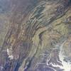 This regional view shows the striking visual effect of the valley-and-ridge topography of the Appalachian Mountains as viewed from the International Space Station. The image shows more than 500 km (300 mi) of this low mountain chain from northeast Pennsylvania (top right) to southern West Virginia, where a dusting of snow covers a patch of land (lower left). 

Sunglint reflections reveal details of the Chesapeake Bay and the great bend of the Potomac River. Cities are difficult to detect from space during daylight hours, so the sickle-shaped bend of the river is a good visual guide for astronauts trying to photograph the nation's capital, Washington D.C. The farm-dominated Piedmont Plateau is the light-toned area between the mountains and the bay. 

The Appalachian Mountains appear striped because the ridges are forested, providing a dense and dark canopy cover, while the valleys are farmed with crops that generally appear as lighter-toned areas. (Farmland is even lighter than usual in this image because the fields are fallow after the harvest.) Photo courtesy of NASA.